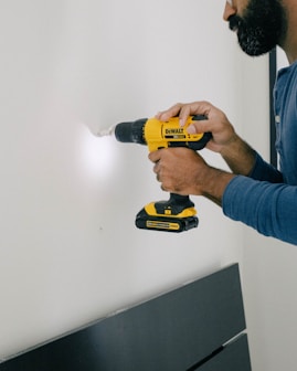 person holding yellow and black cordless hand drill