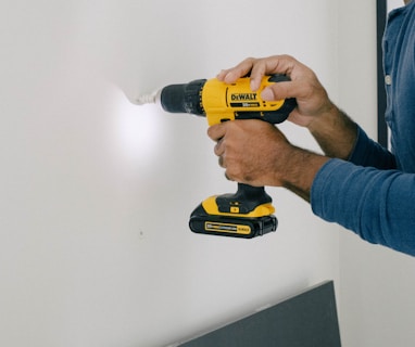person holding yellow and black cordless hand drill