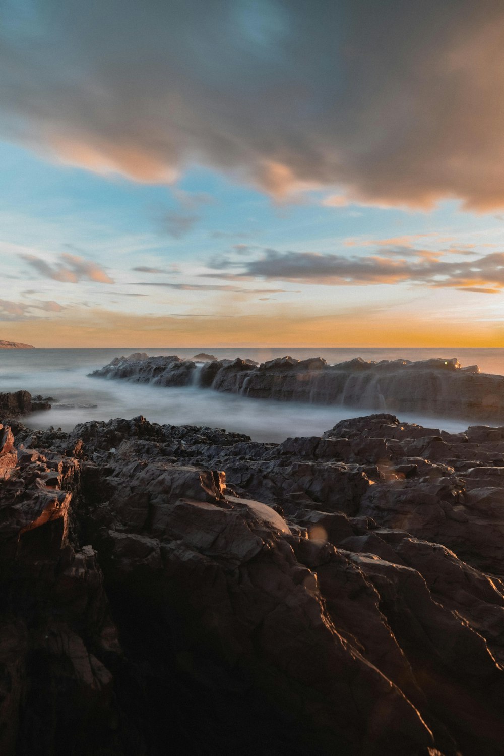 person standing on rock formation near sea during daytime