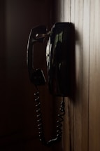 an old fashioned telephone hanging on a wooden wall