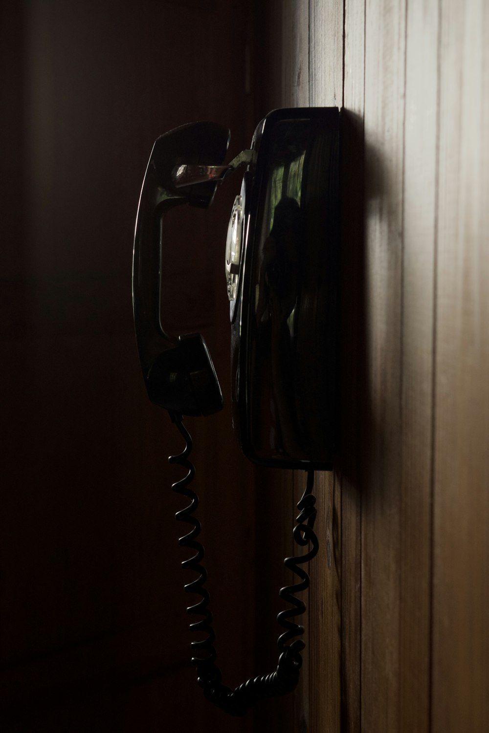 an old fashioned telephone hanging on a wooden wall