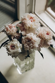 Soft pink peonies arranged elegantly in a rustic vase