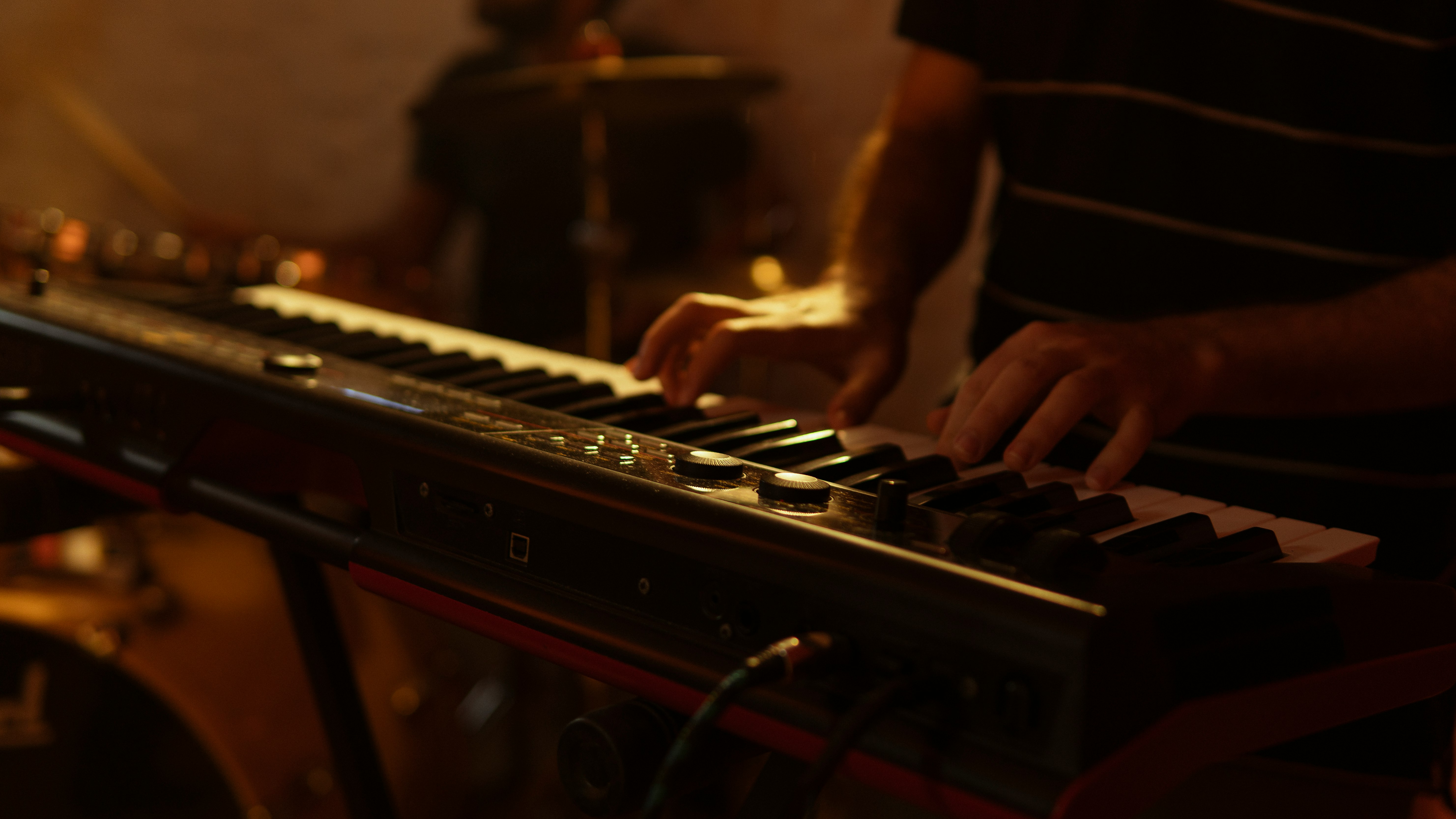 person playing brown and black electric piano