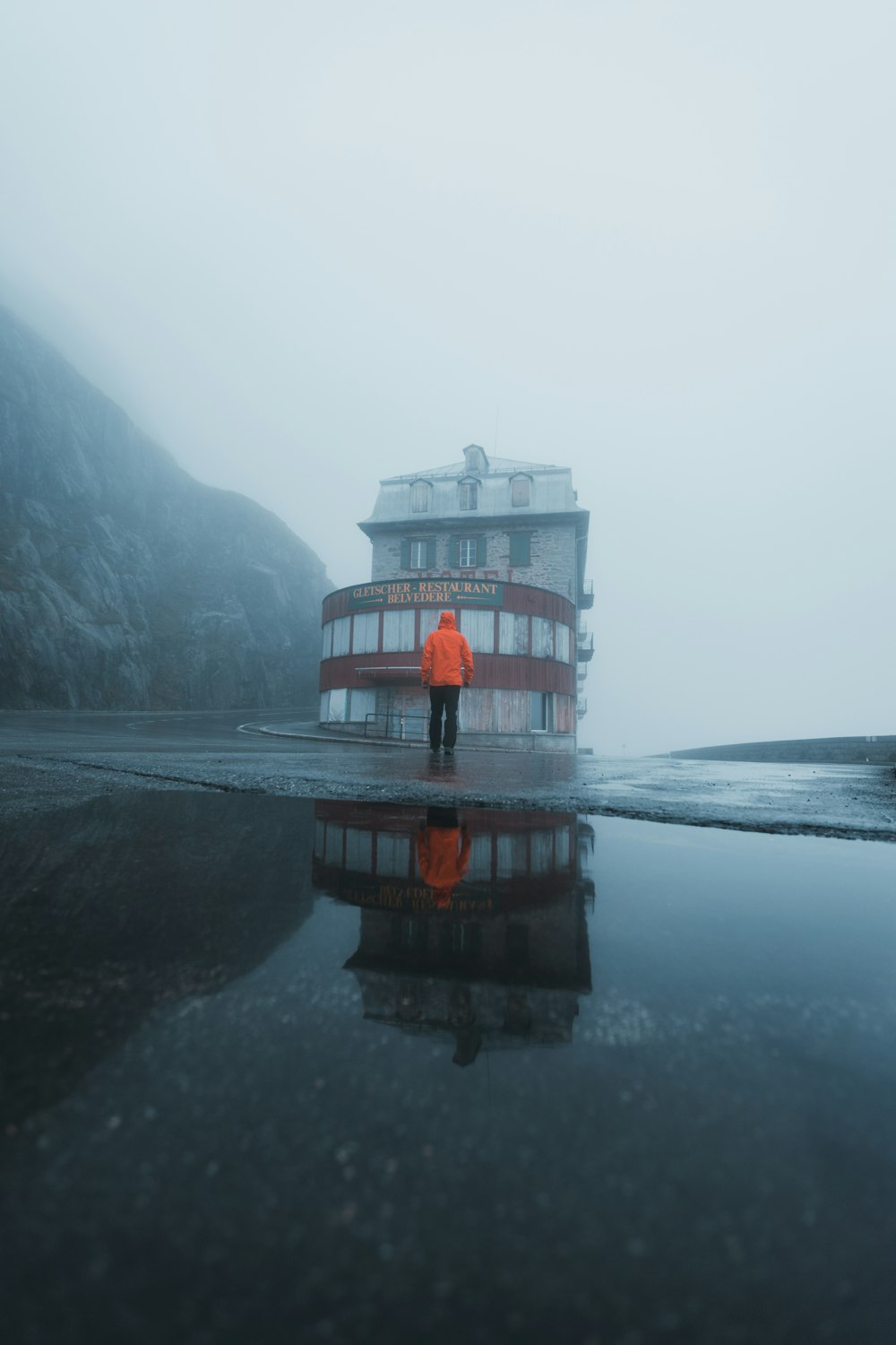 a person standing in front of a building on a foggy day