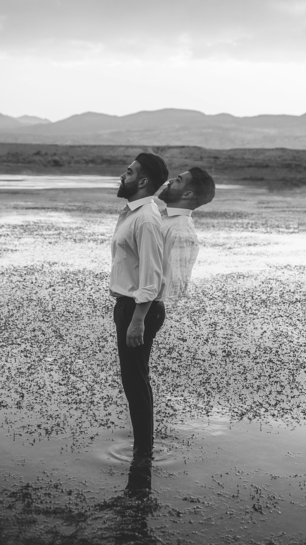 boy in white dress shirt and black pants walking on seashore during daytime