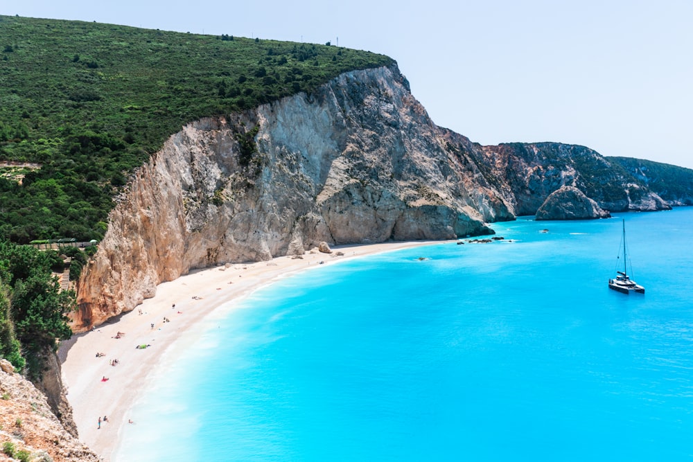 green mountain beside blue sea during daytime