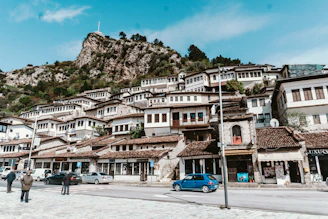 blue car parked near brown concrete building during daytime