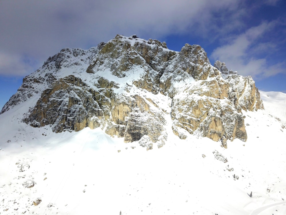 a large mountain covered in snow under a blue sky