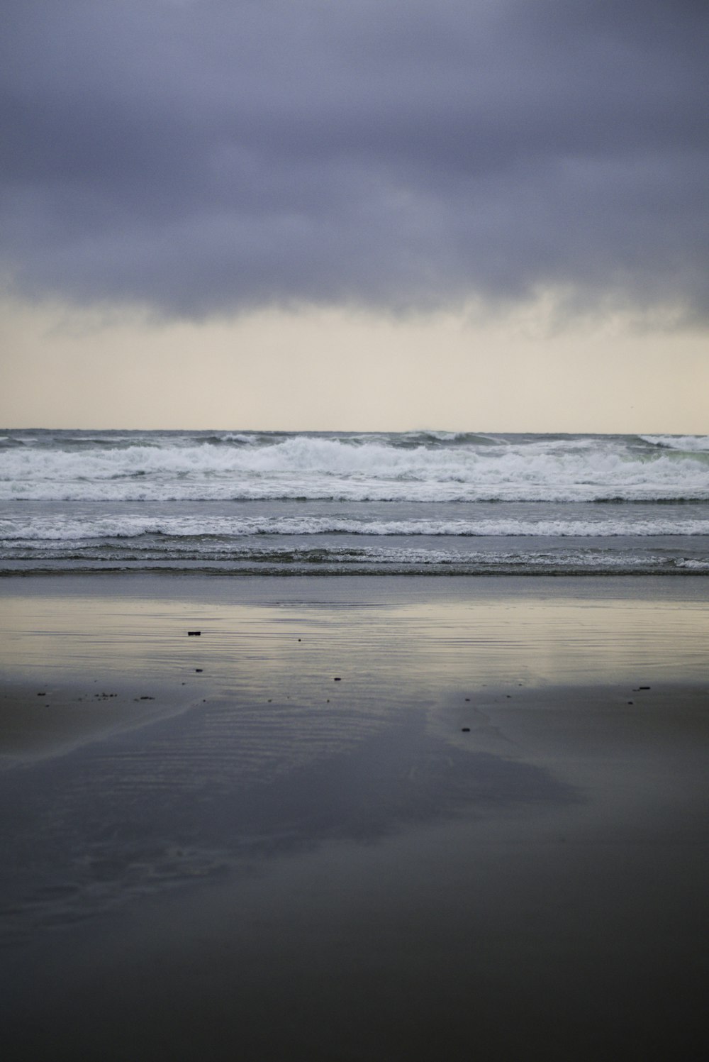 a person walking on a beach with a surfboard