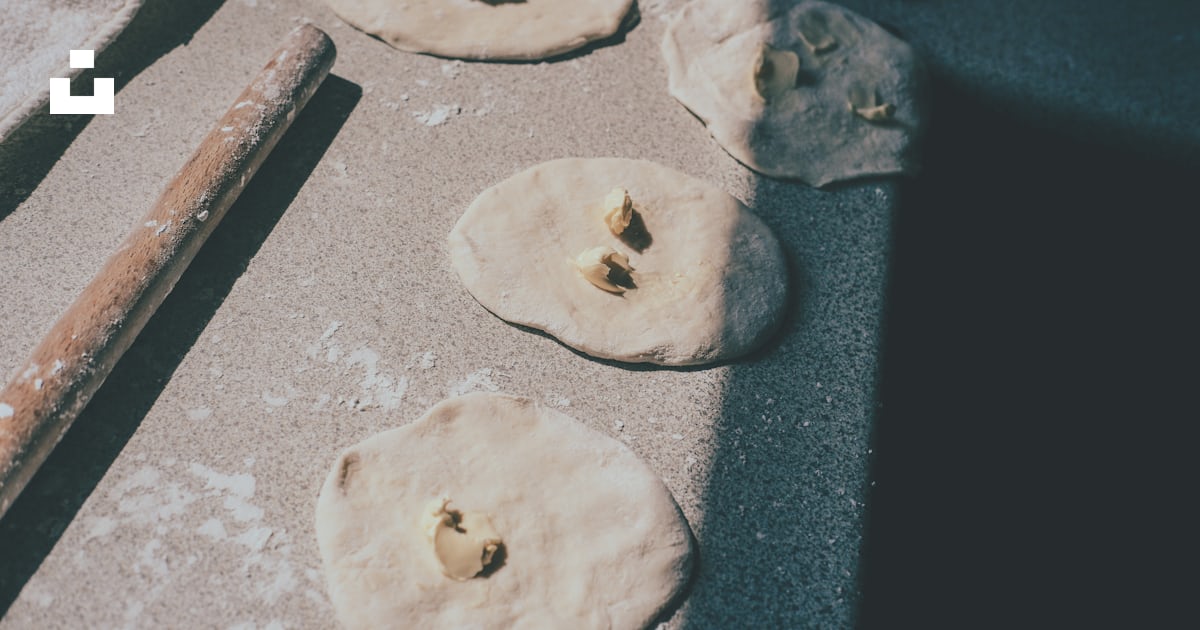 Four uncooked pizza doughs on a baking sheet photo Free Food Image on