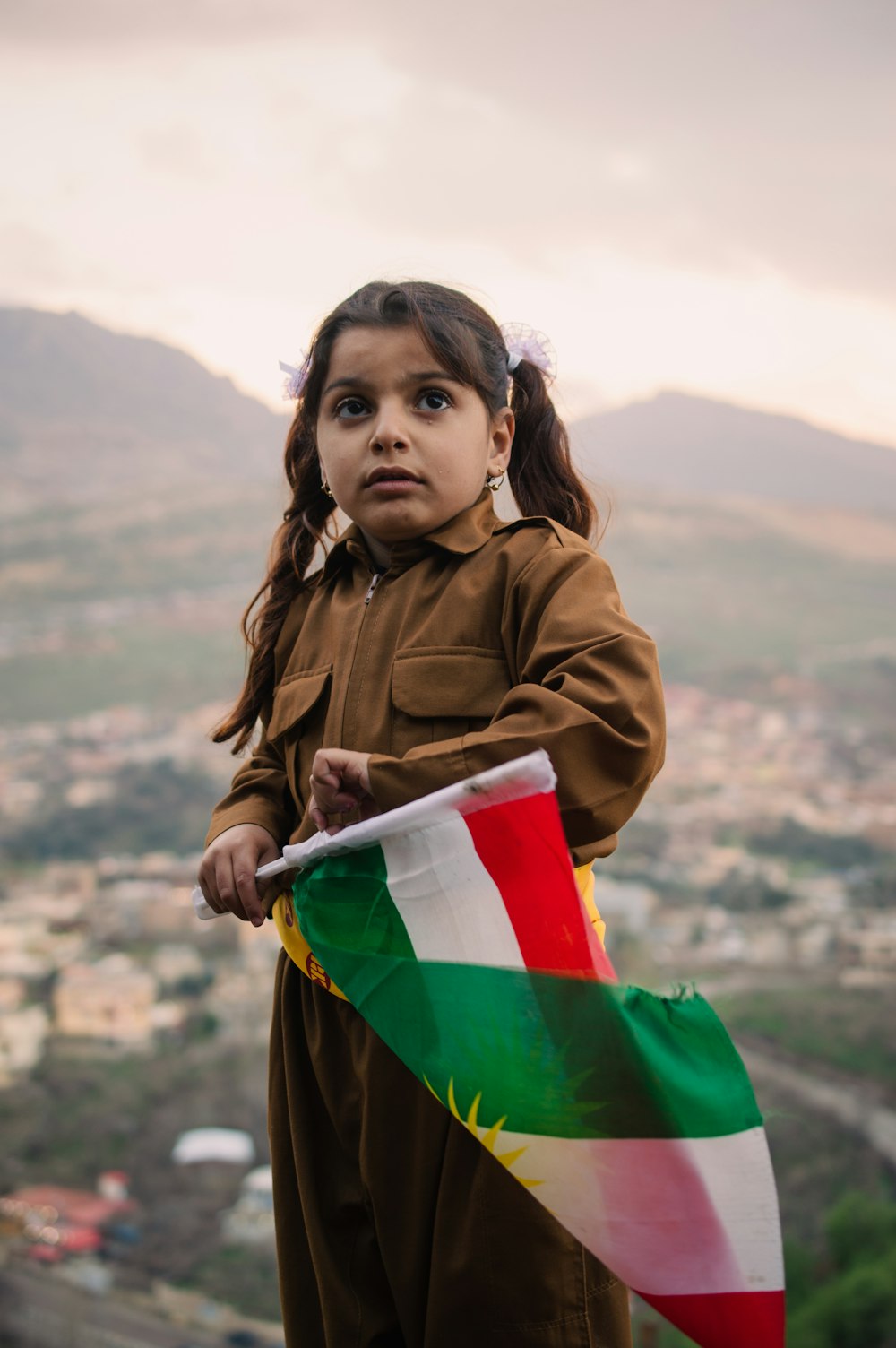 girl in brown jacket holding flag