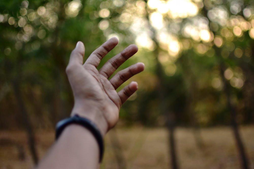 Die Hand einer Person, die nach etwas in der Luft greift