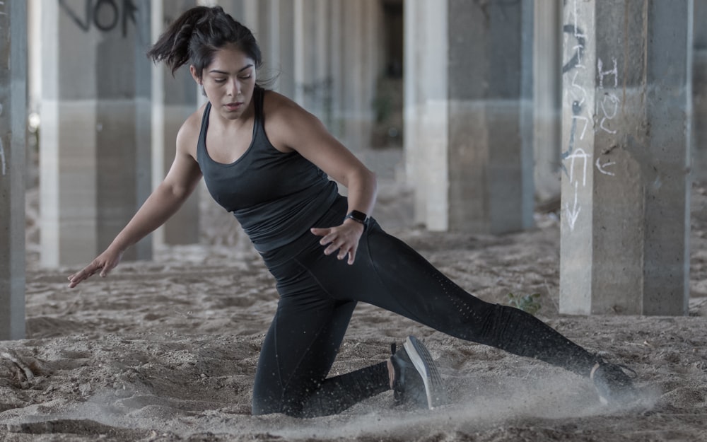 woman in black tank top and black leggings doing yoga