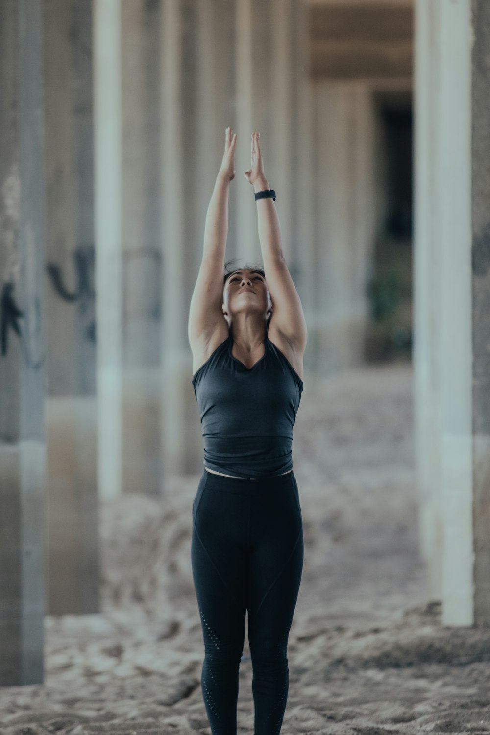 woman in blue tank top and black leggings doing yoga