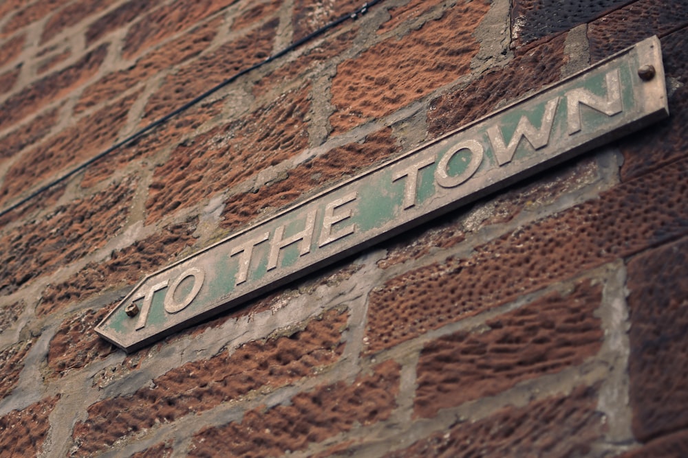 a sign on a brick wall that says to the town