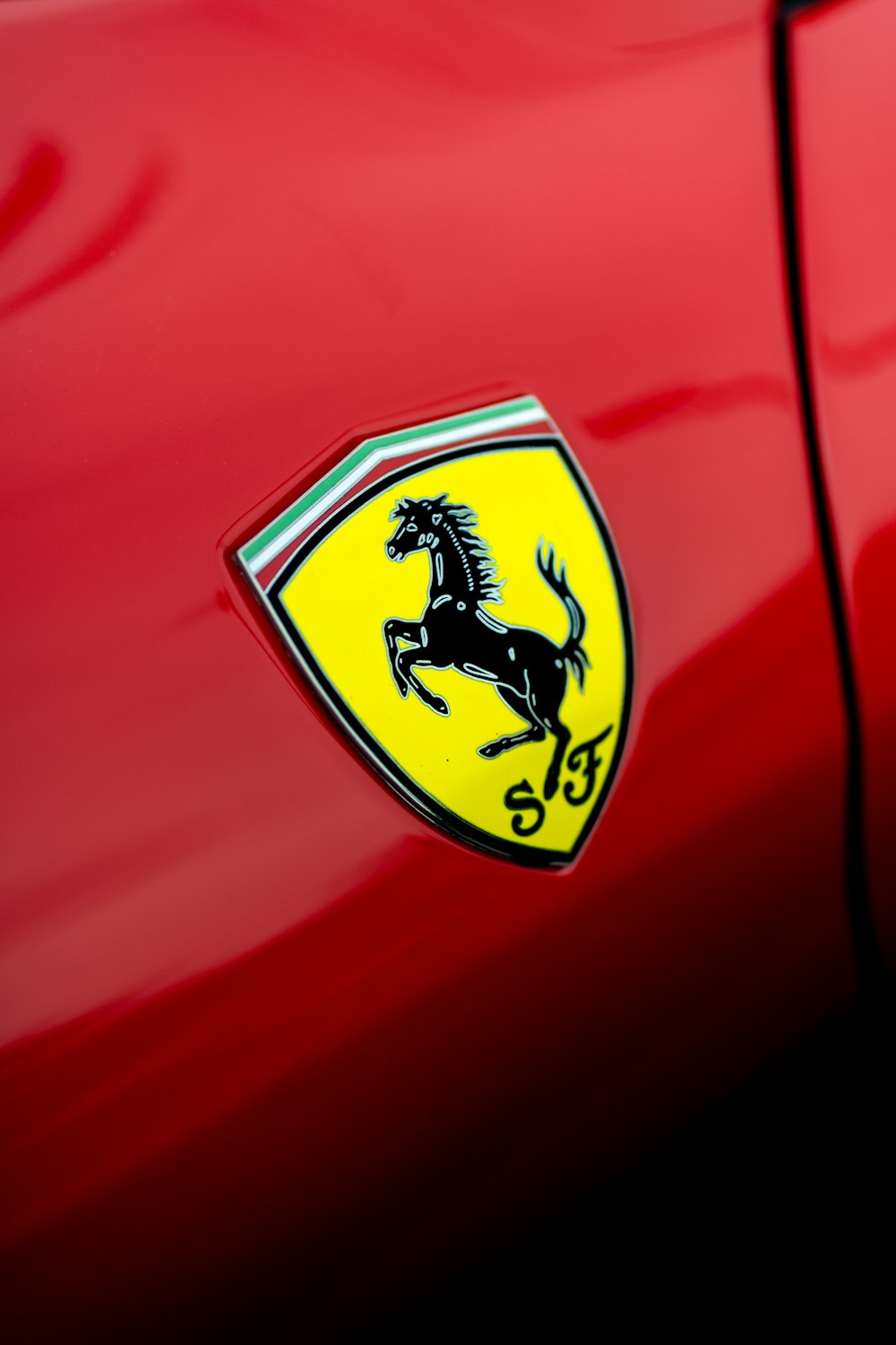 um close up de um emblema da Ferrari em um carro vermelho