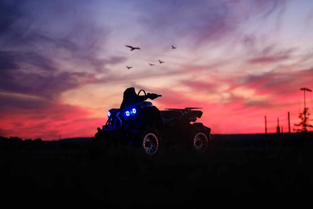 a person riding an atv in a field at sunset