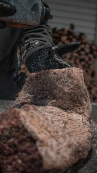 person in black pants and black shoes standing on brown rock