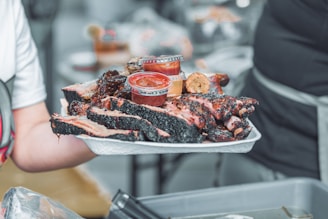 person holding white ceramic tray with sliced of pizza