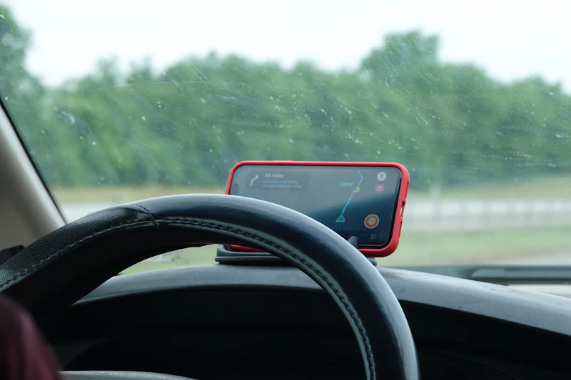 Phone showing GPS map navigation mounted on a car dashboard