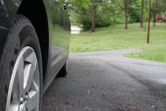A close-up of cash being exchanged for a car in a driveway.