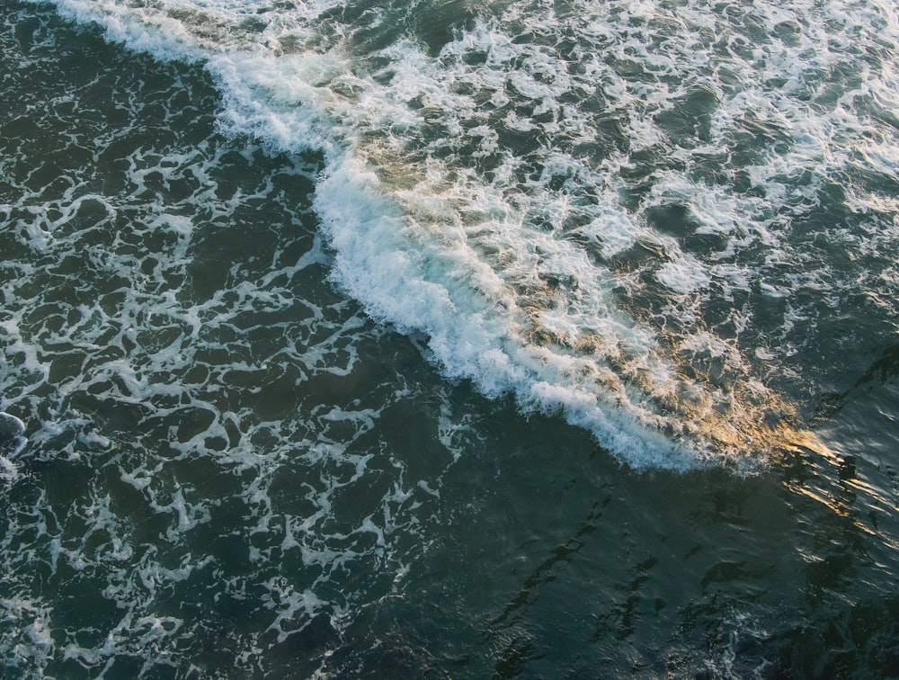 ocean waves crashing on shore during daytime