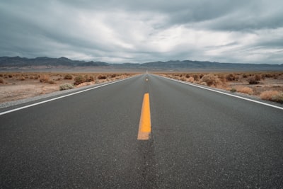 black asphalt road under cloudy sky during daytime trips teams background