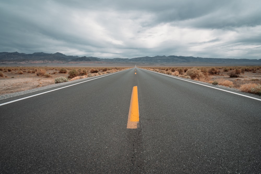 Carretera de asfalto negro bajo cielo nublado durante el día