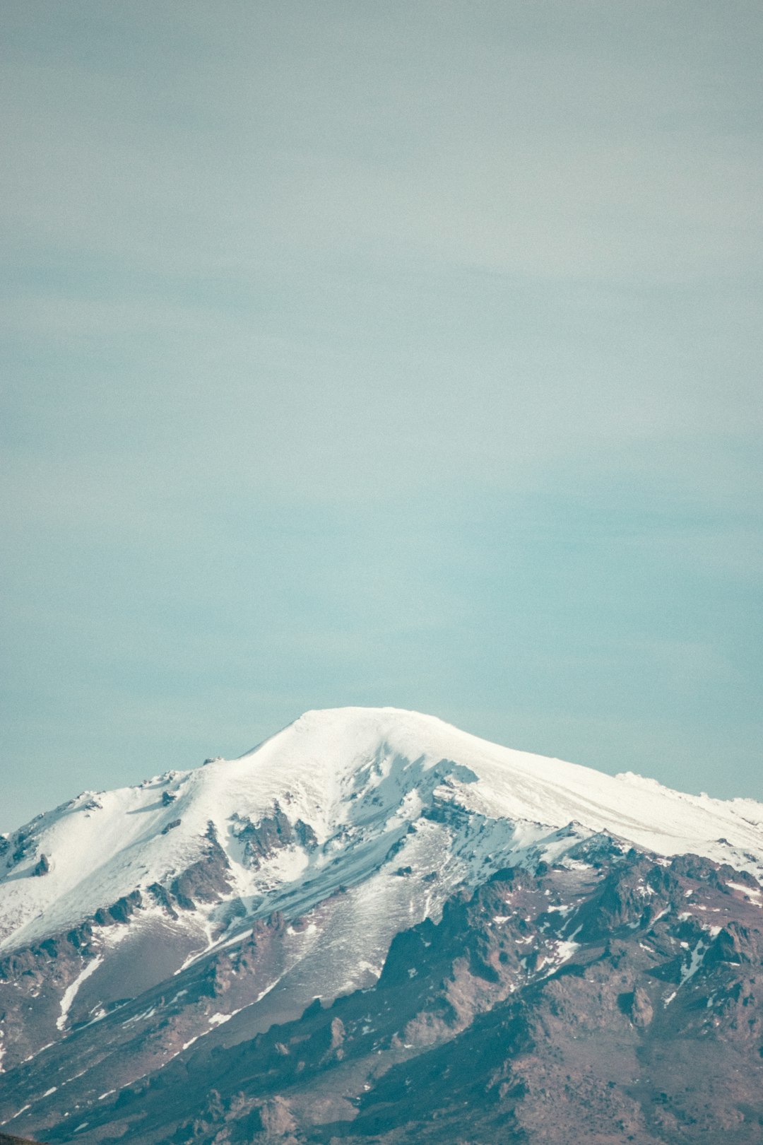 snow covered mountain under gray sky