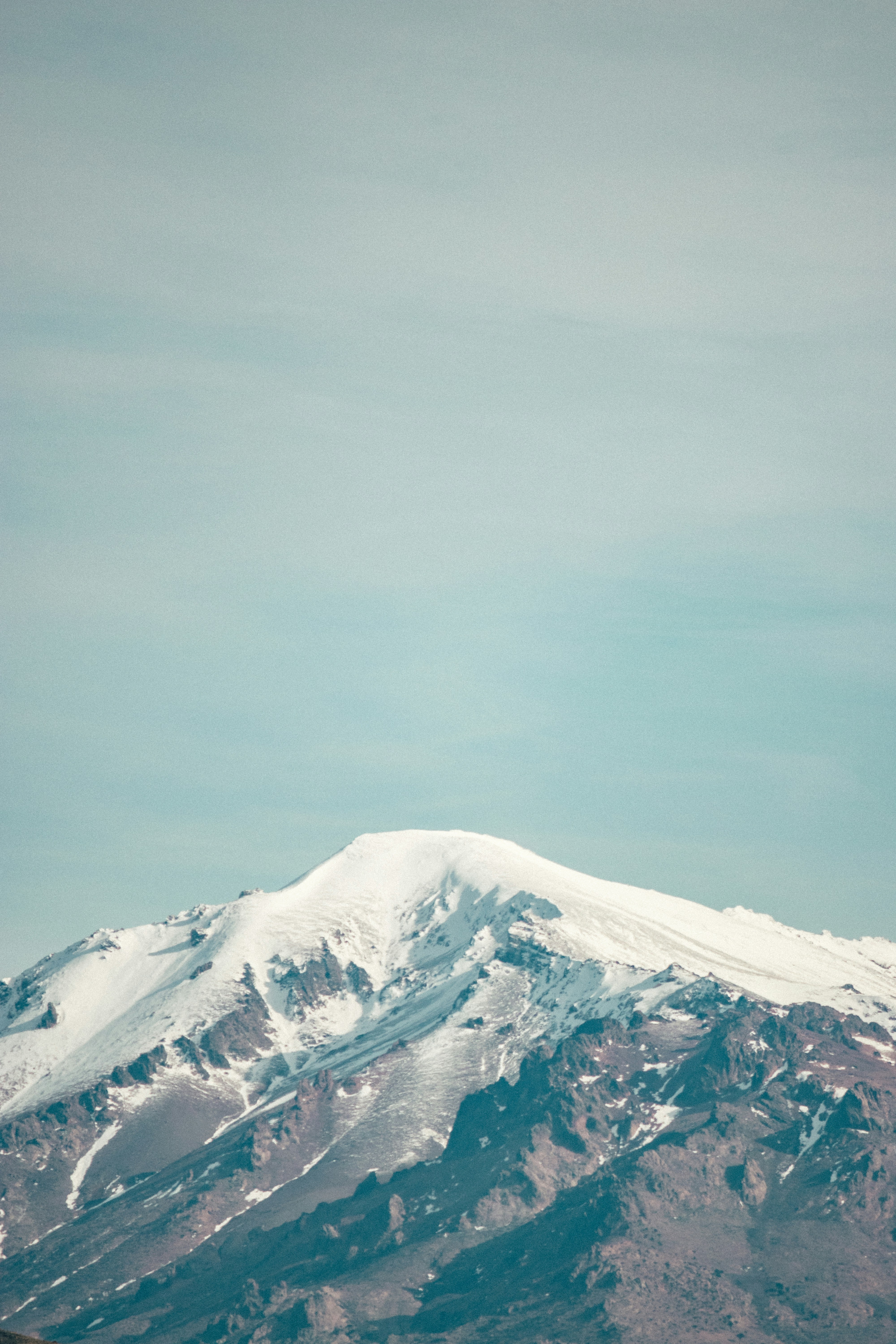 snow covered mountain under gray sky