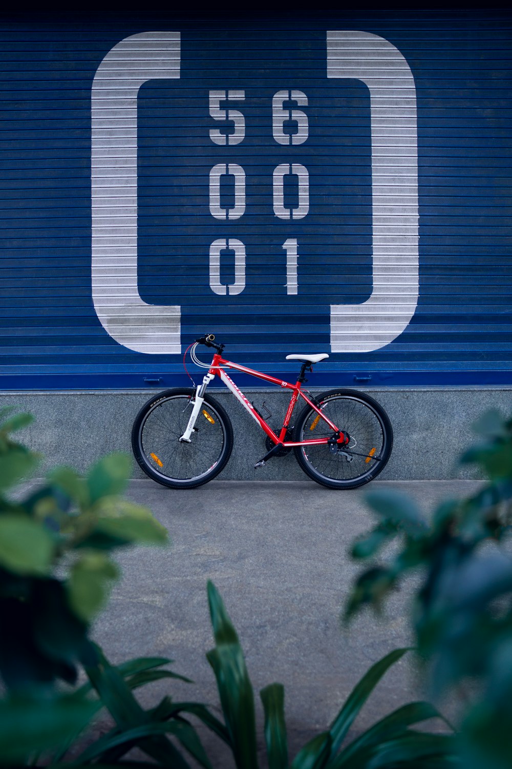 a red bike parked in front of a garage door
