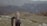 a woman with a backpack on top of a mountain