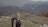 a woman with a backpack on top of a mountain