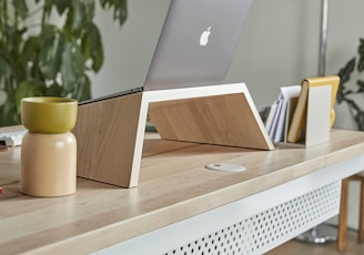 a laptop computer sitting on top of a wooden desk