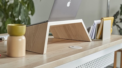 a laptop computer sitting on top of a wooden desk