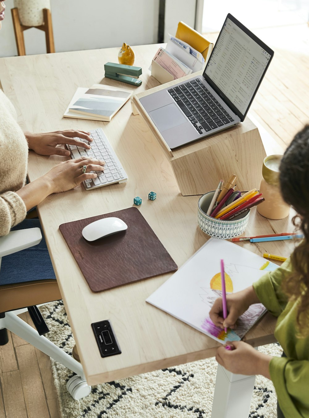 Una mujer sentada en una mesa con un niño usando una computadora portátil