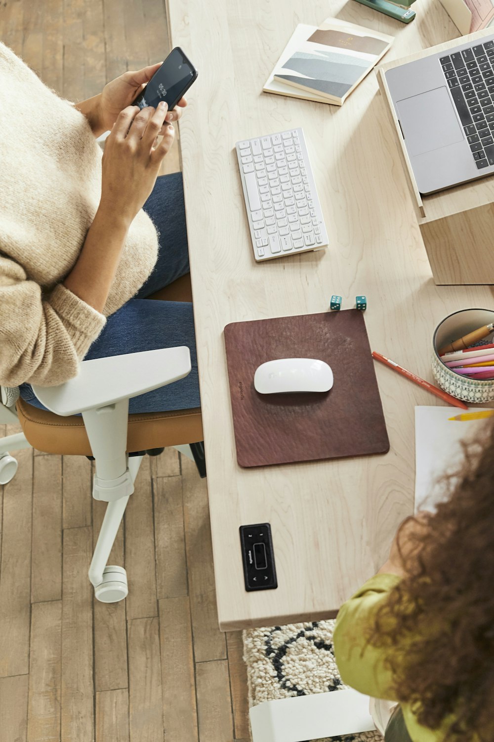 Una mujer sentada en un escritorio usando un teléfono celular