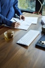 a woman sitting at a desk with a keyboard and papers