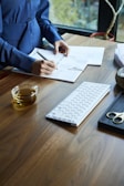 a woman sitting at a desk with a keyboard and papers