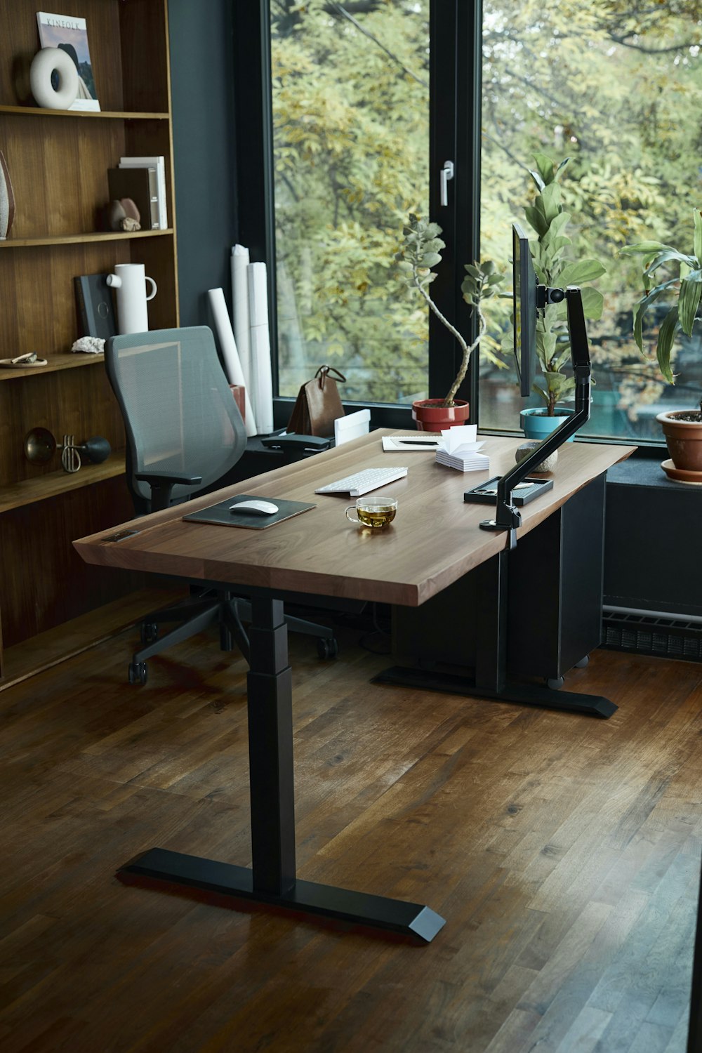 a desk with a laptop on it in front of a window