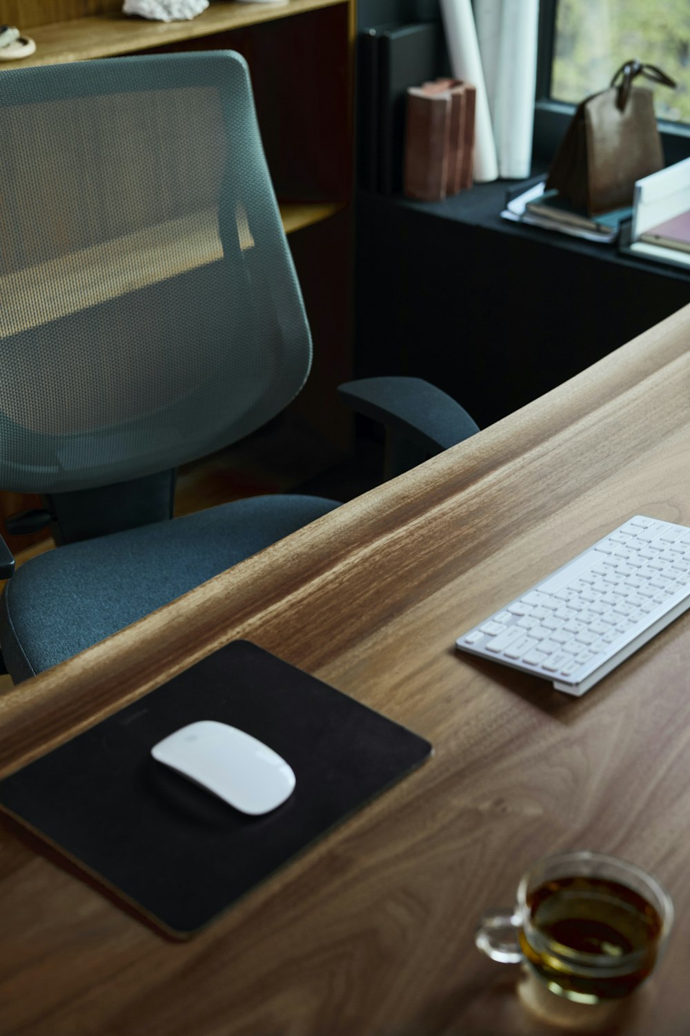 a desk with a computer mouse, keyboard and a mouse pad