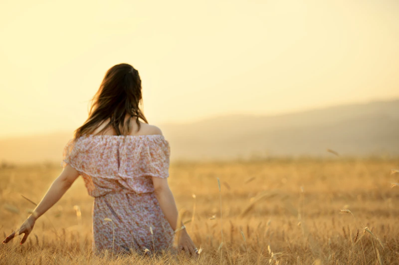 Sugar mommy caminando por un campo de hierba alta