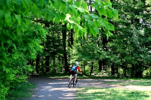 A cyclist wearing a durable, stylish helmet riding through a forest trail