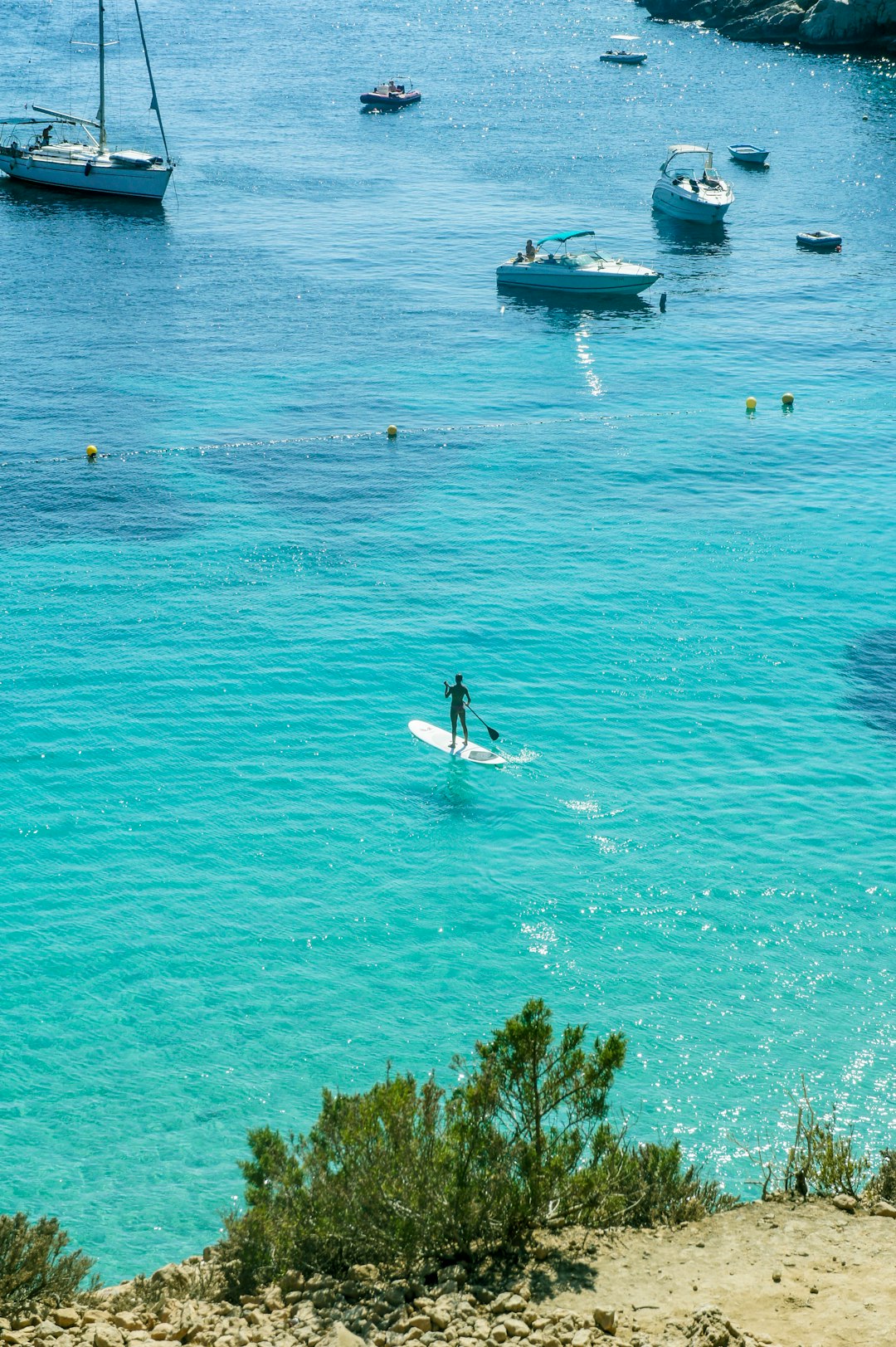 man in white shirt riding on white and blue boat on blue sea during daytime