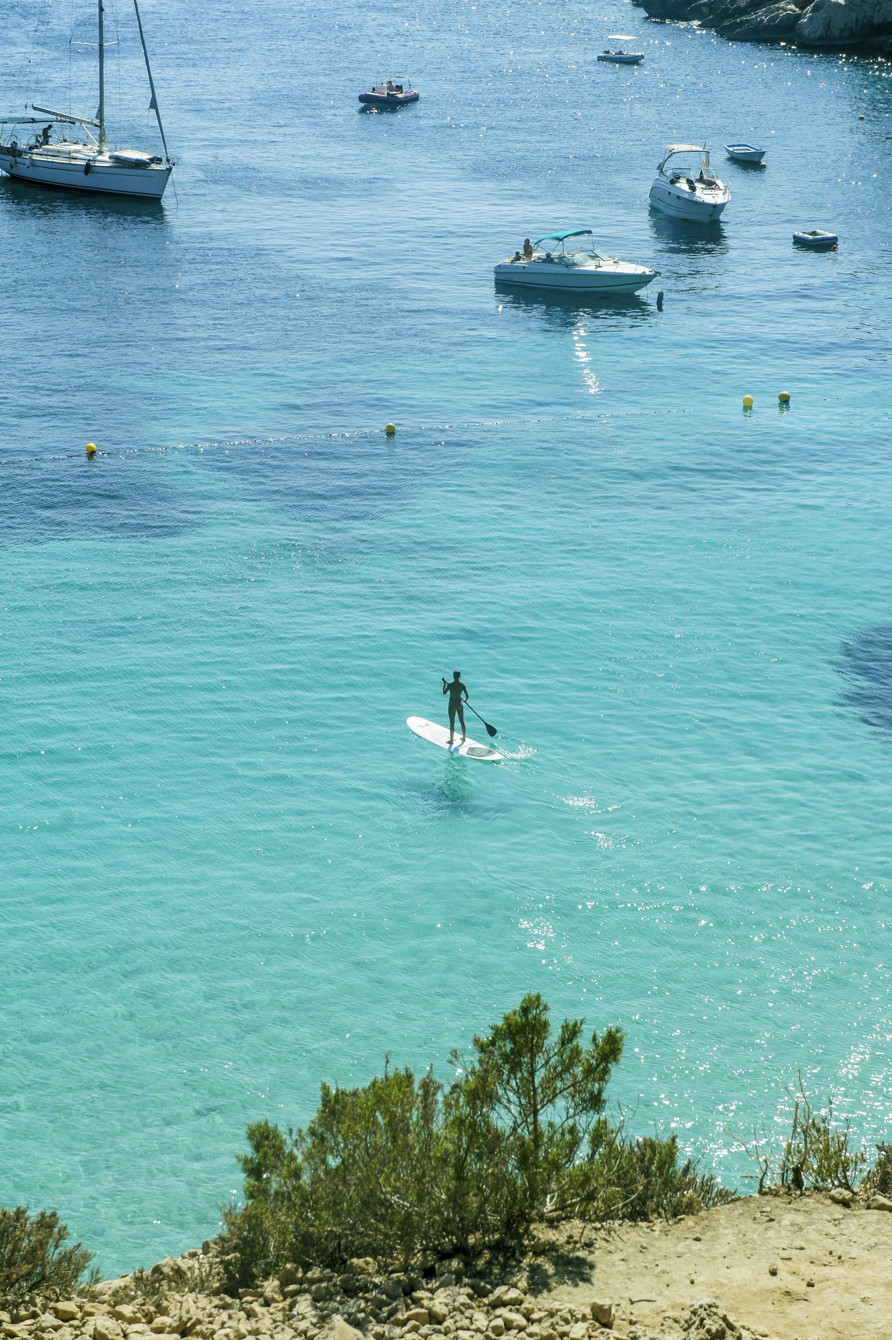 man in white shirt riding on white and blue boat on blue sea during daytime