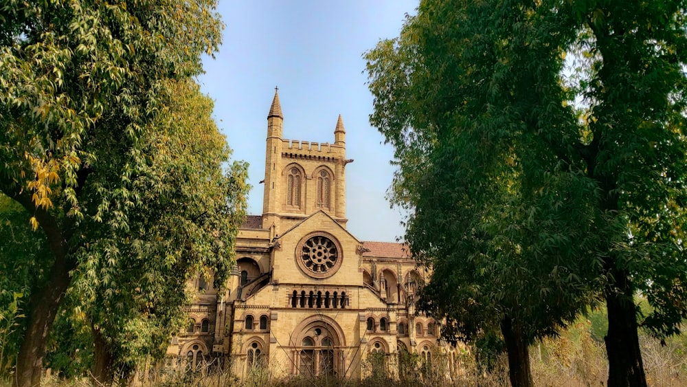 an old church surrounded by trees on a sunny day