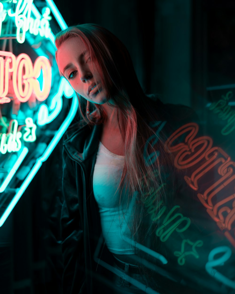 woman in white tank top standing near neon signage