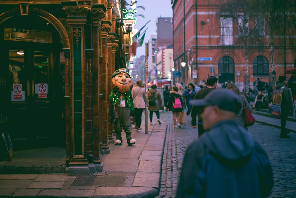 a group of people walking down a street next to tall buildings