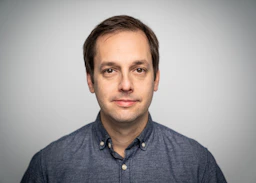 a man in a blue shirt is posing for a picture