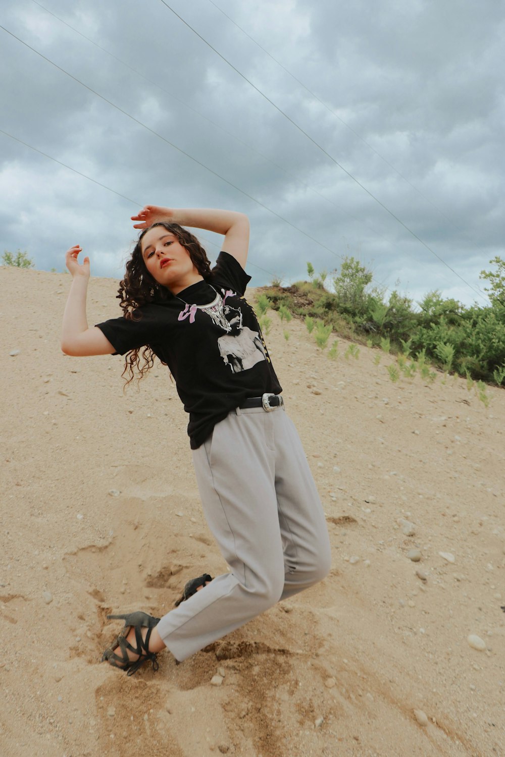 woman in black and white shirt and gray pants raising her hands